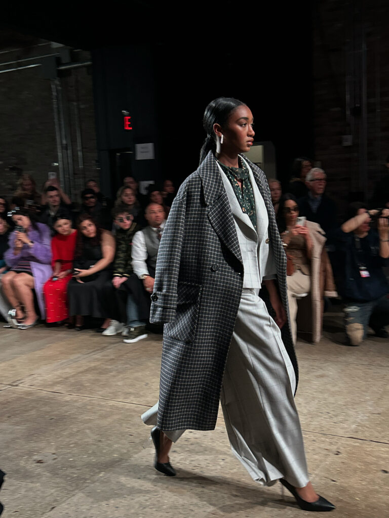 black woman wearing a suit on a fashion runway