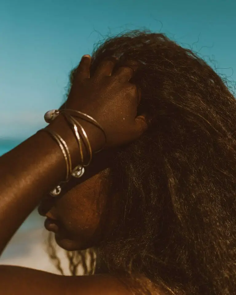 close up of woman touching hair on beach